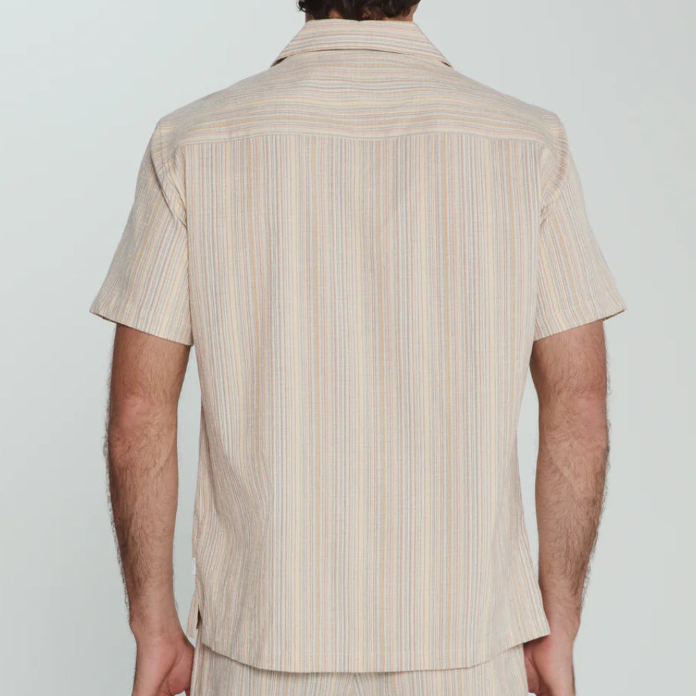 Man wearing a beige striped shirt and pants against a white background