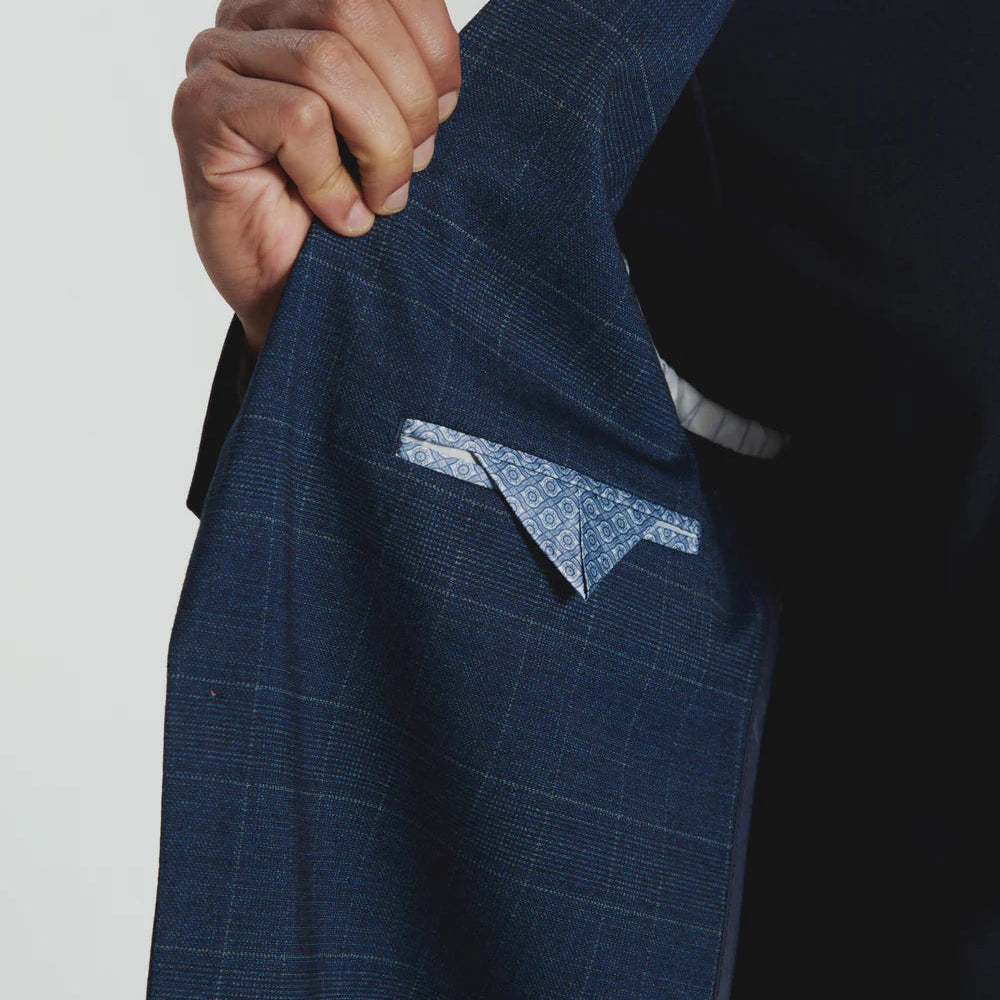 Blue checkered suit jacket with a hand holding it against a white background