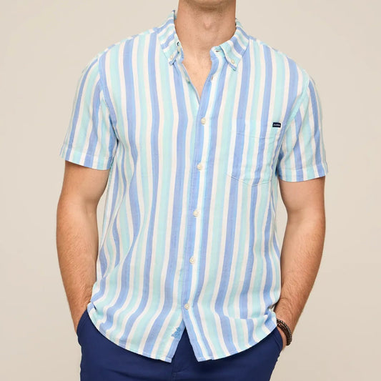 Man wearing a striped shirt and navy shorts against a beige background