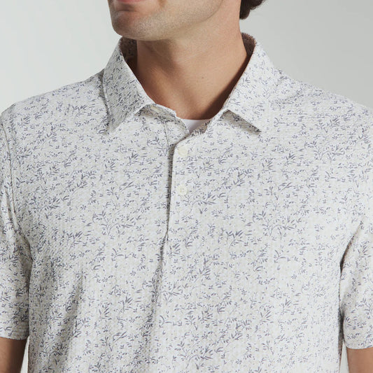 Man wearing a patterned white shirt against a plain background